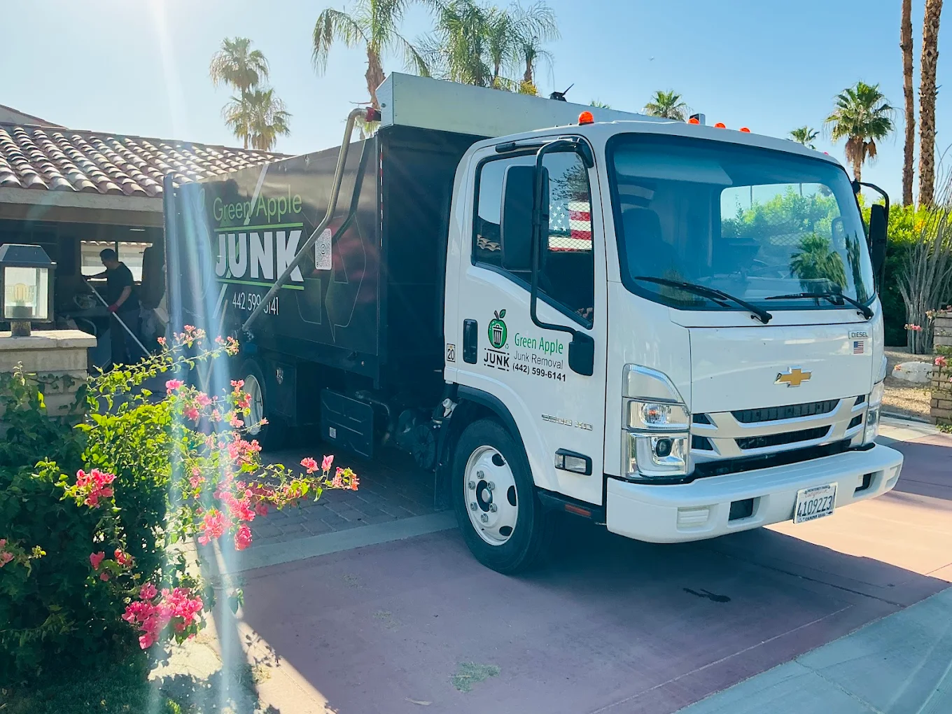 Green Apple branded junk truck parked at residential neighborhood in Coachella Valley